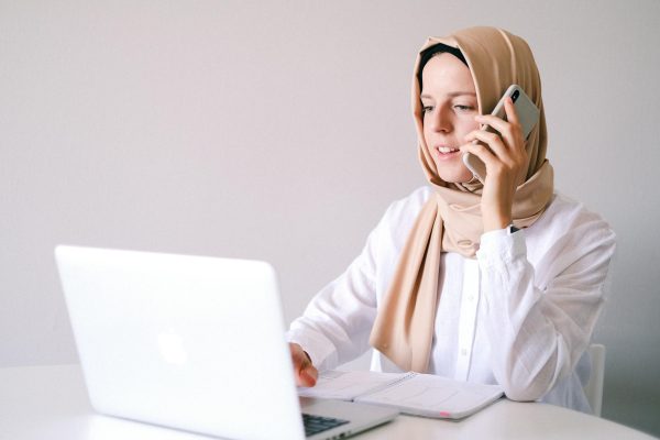 Woman in White Long Sleeve Shirt Wearing Hijab Using Laptop